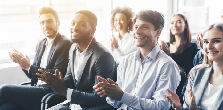 applauding-to-speaker-group-of-happy-business-people-in-conference-hall
