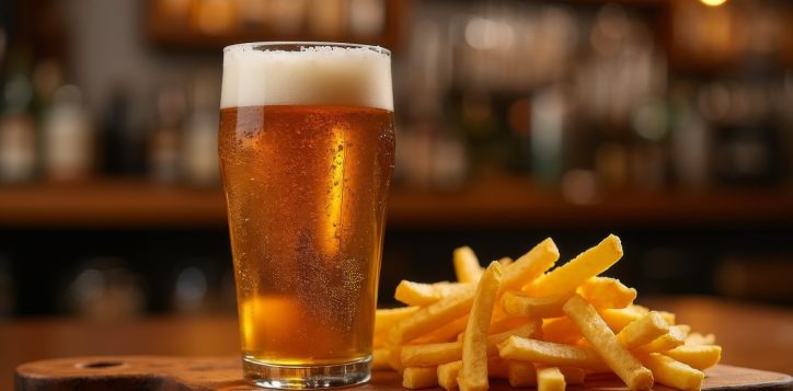 pint-of-golden-beer-with-frothy-foam-served-alongside-crispy-french-fries-on-a-wooden-board-in-a-cozy-bar-setting-with-warm-lighting-2
